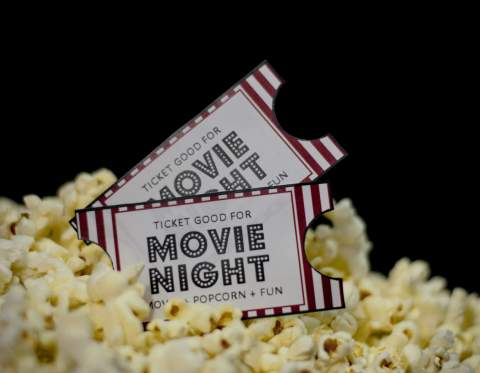 Two tickets that read "movie night" in a pile of popcorn