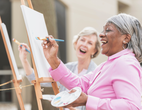 Two women painting at canvas easels