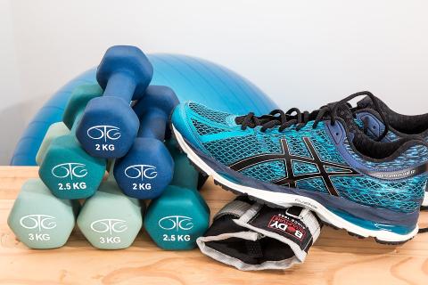 Weights, ball, brace, and sneaker standing ready for a workout