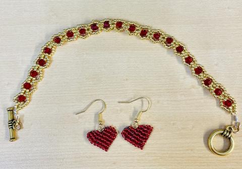Bracelet and earing combo: bracelet in gold and red beads, earrings are heart shaped weaved beads