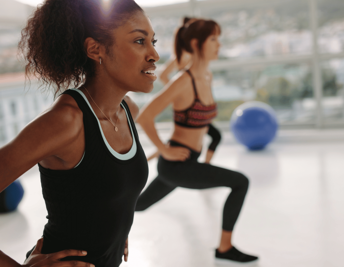 Woman at the front of a fitness class in a lunge